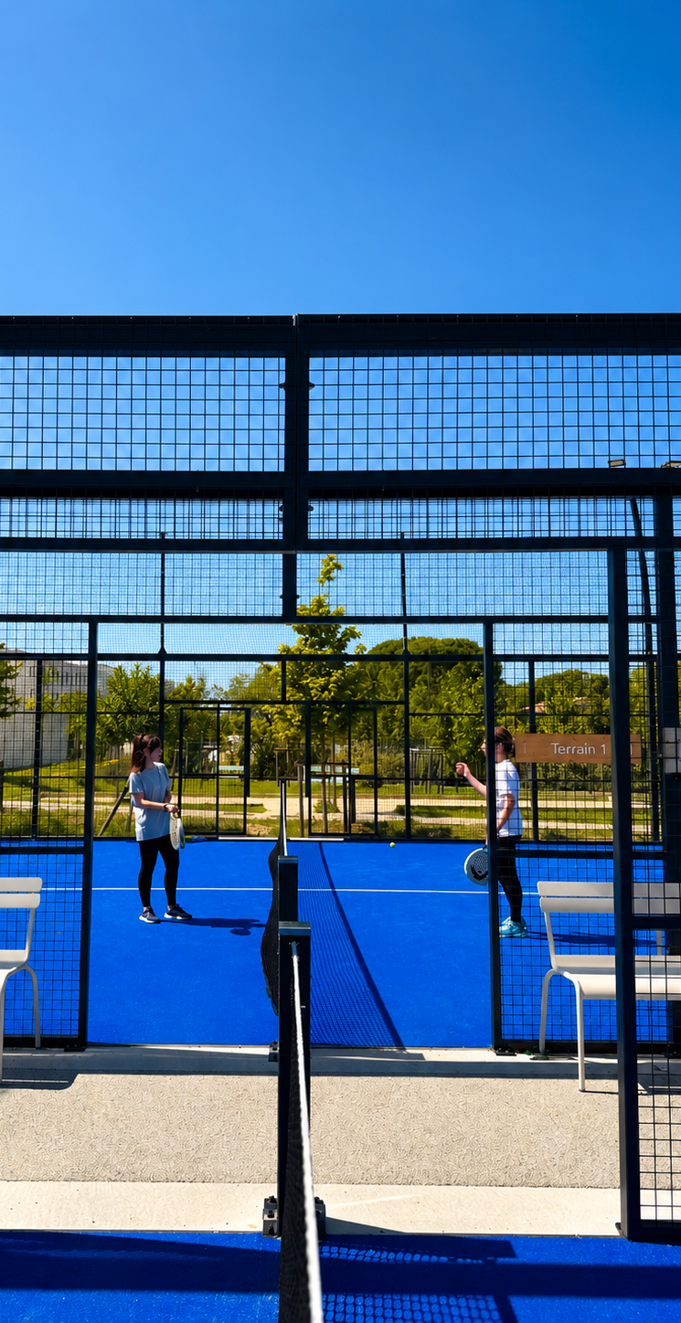 Raquette de padel et balle sur un court bleu.